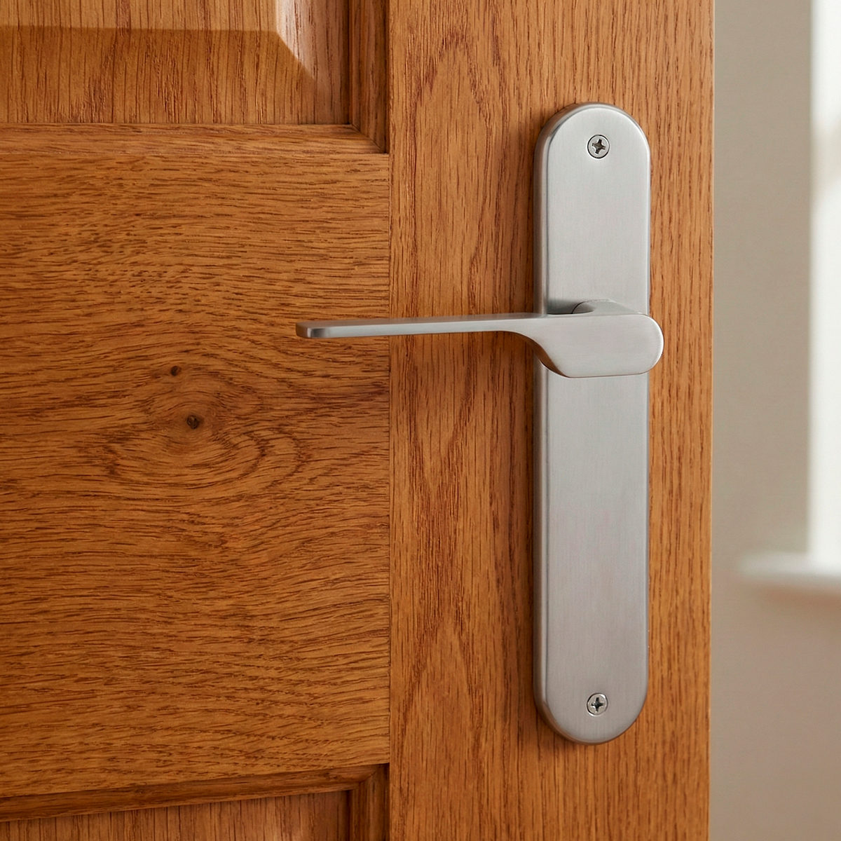 Maniglia modello '640' con placca ovale per porte in zama, finitura nichel satinato e impugnatura moderna